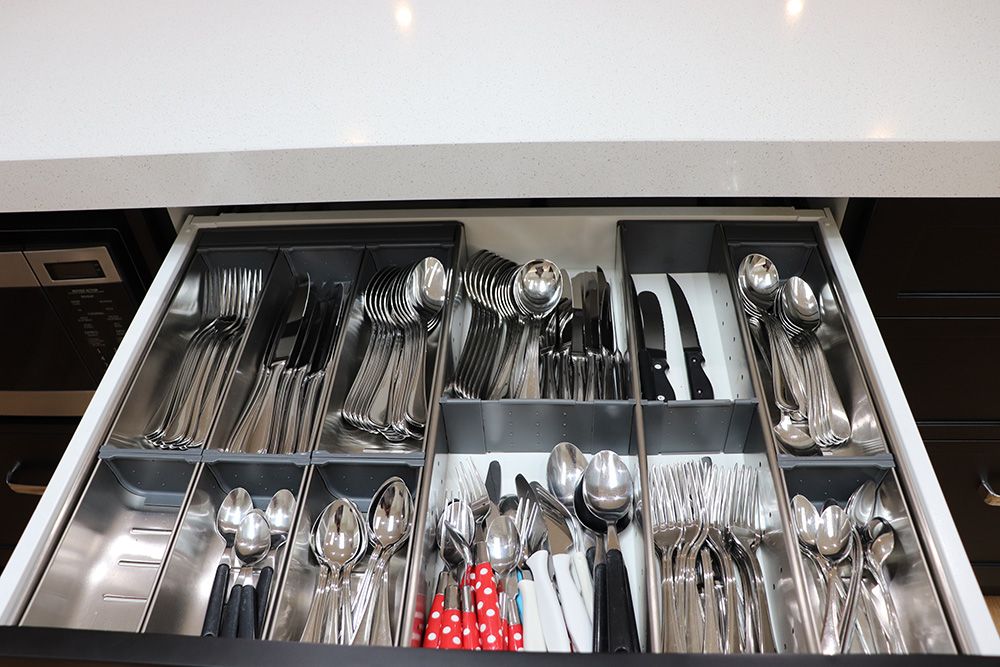 Cutlery storage drawer with stainless steel dividers and organised utensils