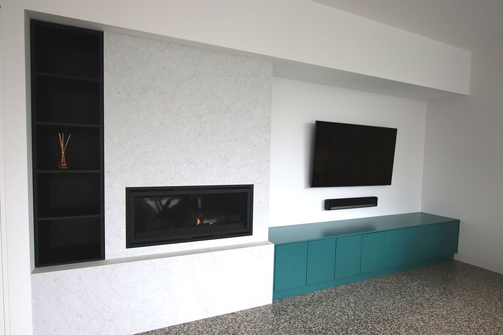 Custom TV and entertainment unit with fireplace and display shelving by Complete Style Joinery