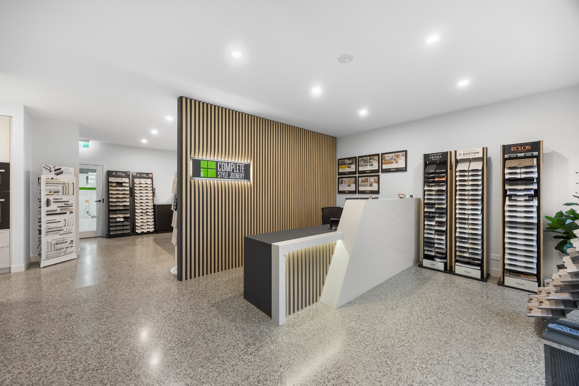 Showroom reception desk with timber batten feature wall and brand signage
