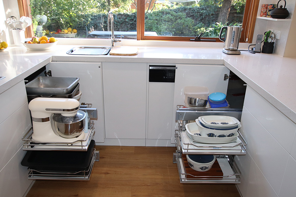 Pull out shelf system under a kitchen sink for mixer and baking dishes