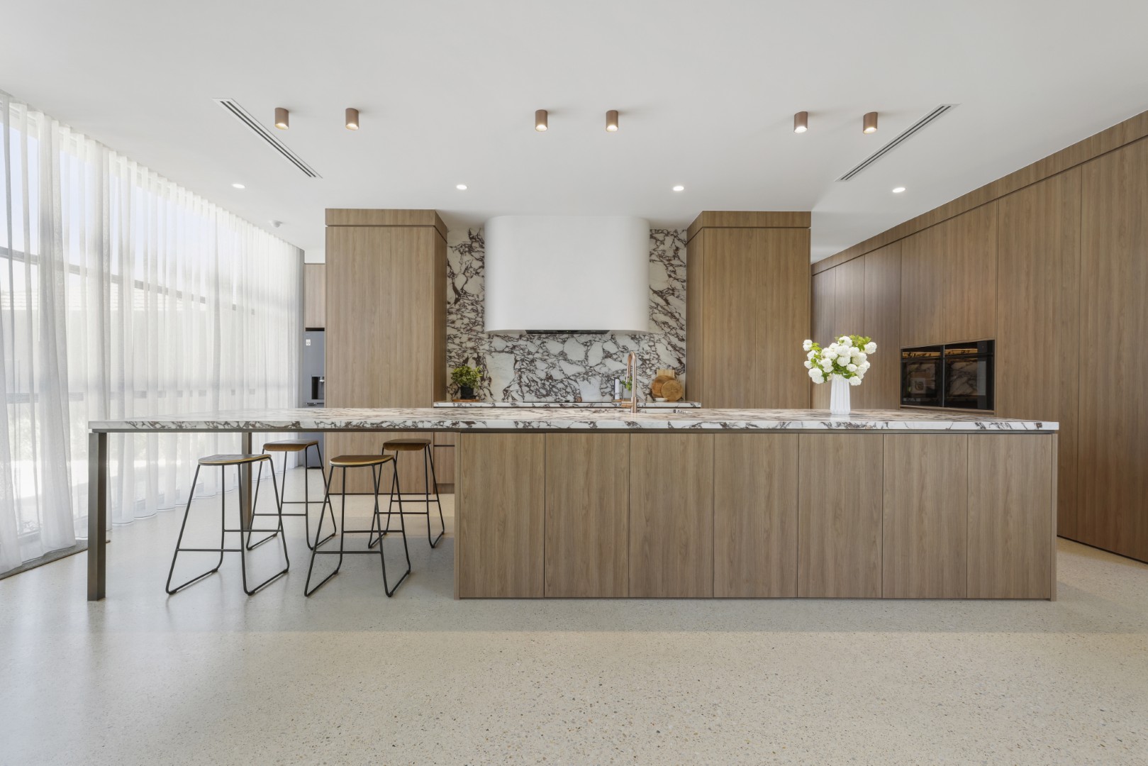 Modern timber kitchen with marble island bench and splashback