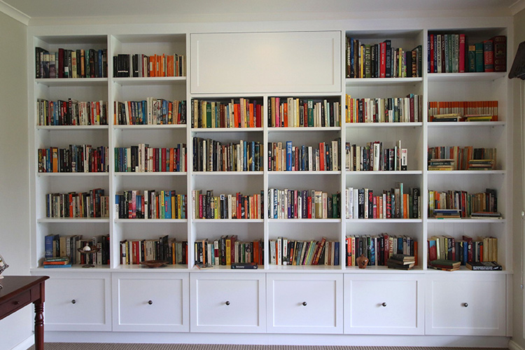 Full wall custom bookcase with cabinetry drawers and open shelving