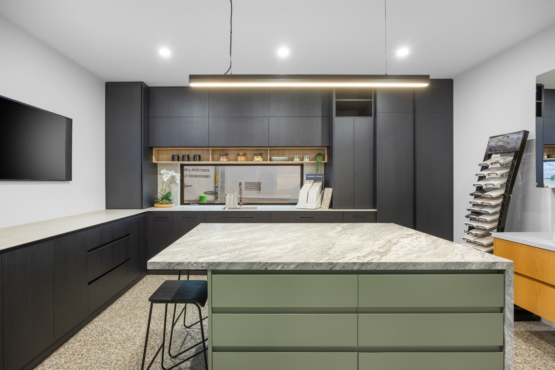 Dark display kitchen with open timber shelving and marble look island