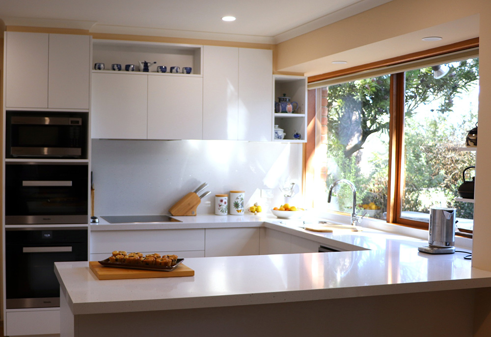 Gloss white kitchen with seamless overhead cupboards