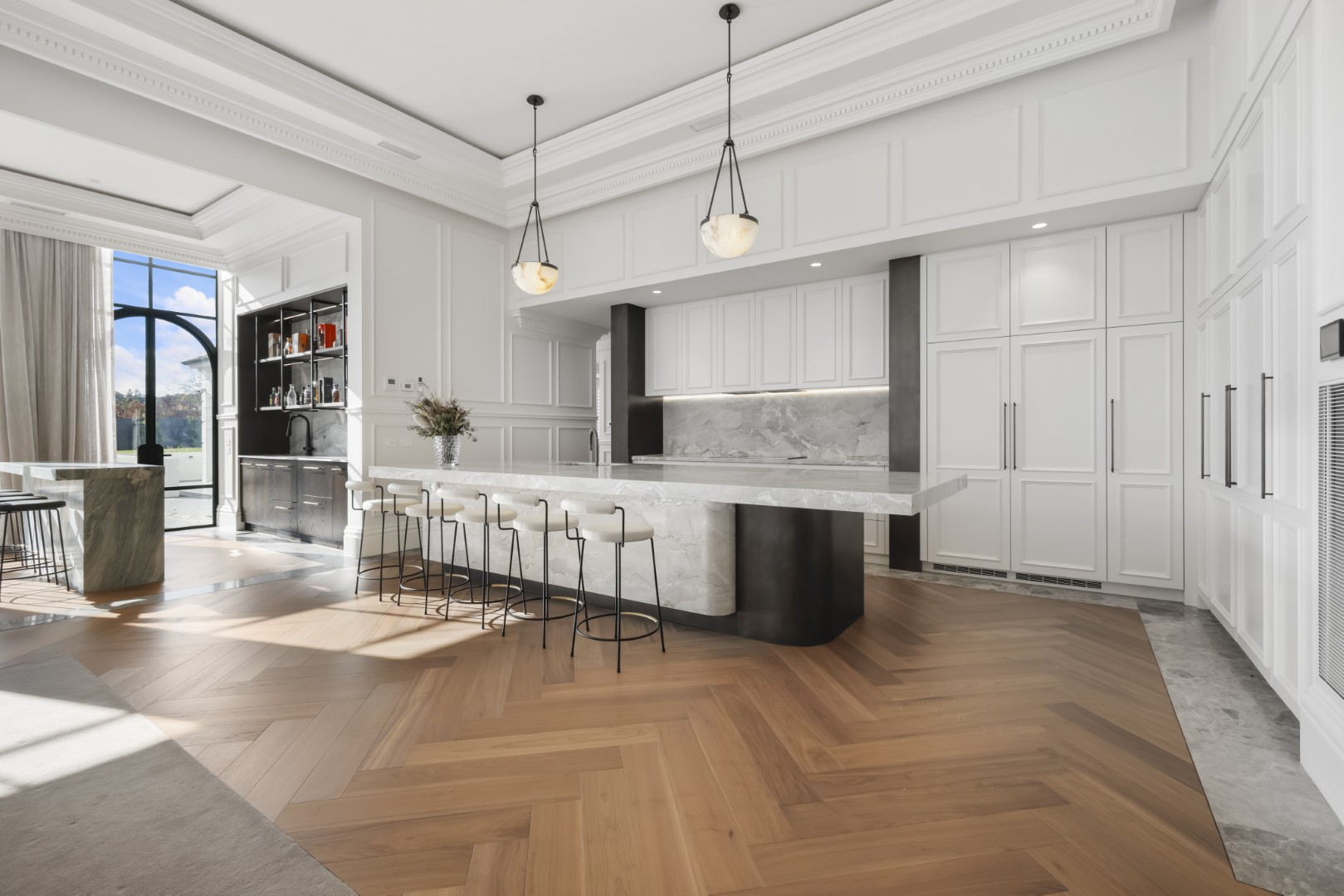 Modern white kitchen with marble island bench, pendant lighting and herringbone timber flooring by Complete Style Joinery