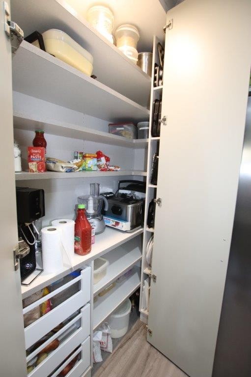 Completed walk in pantry with shelving, drawers and appliance storage
